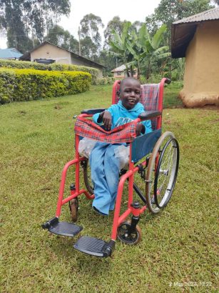 Clinton zufrieden in seinem Kinder-Rollstuhl