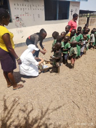 Sister Ligia und Patricia verteilen Milch und Kekse
